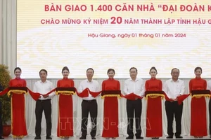 Chủ tịch nước Võ Văn Thưởng cùng các đại biểu thực hiện nghi thức bàn giao 1.400 căn nhà Đại đoàn kết tặng hộ nghèo Hậu Giang. (Ảnh: Thống Nhất/TTXVN)