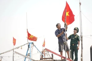 Bộ đội biên phòng tỉnh Quảng Ngãi cùng ngư dân treo cờ Tổ quốc