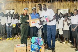 Trung tá Bùi Phương Lân thay mặt Tổ công tác Bộ Công an tại phái bộ UNMISS trao quà cho các em học sinh tại Trường Tiểu học Thống nhất, Nam Sudan. (Nguồn: Bộ Công an)
