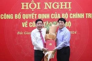 Đồng chí Lương Cường, Ủy viên Bộ Chính trị, Thường trực Ban Bí thư trao quyết định và tặng hoa chúc mừng đồng chí Nguyễn Văn Gấu nhận trọng trách mới. 