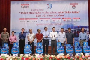 Đại diện lãnh đạo tỉnh Hà Tĩnh và báo Pháp luật Thành phố Hồ Chí Minh trao quà cho bà con ngư dân. (Ảnh: ĐẶNG TRUNG)