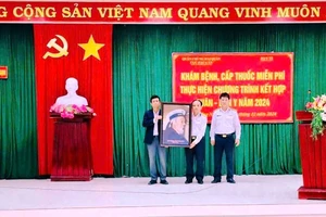 Trưởng đoàn công tác của Vùng 3 Hải quân, Thượng tá Trần Hoàng An tặng quà lưu niệm cho đại diện xã Quảng Ngạn huyện Quảng Điền, tỉnh Thừa Thiên Huế.