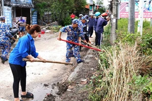 Cán bộ, đoàn viên thanh niên các đơn vị Hải quân và thanh niên địa phương dọn vệ sinh các tuyến đường giao thông ở xã Hàng Vịnh, huyện Năm Căn, tỉnh Cà Mau.