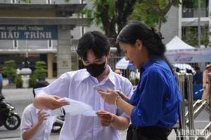 Các thí sinh được tình nguyện viên hỗ trợ, hướng dẫn đến phòng thi theo sơ đồ tại điểm thi Trường THPT Phan Châu Trinh, Đà Nẵng, chiều 26/6. (Ảnh: ANH ĐÀO)