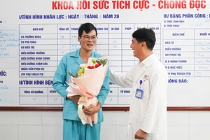 Tiến sĩ, bác sĩ Lê Đức Nhân, Giám đốc Bệnh viện Đà Nẵng tặng hoa, chúc mừng bệnh nhân, sáng 27/11. (Ảnh: ANH ĐÀO)