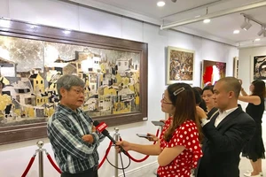 Hoạ sĩ Văn Chiến giới thiệu với báo chí và công chúng về các tác phẩm tại triển lãm.