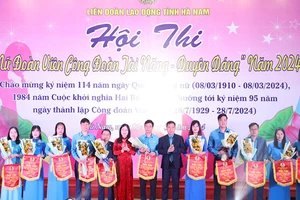 Lãnh đạo Liên đoàn Lao động tỉnh Hà Nam tặng hoa và cờ lưu niệm cho các đơn vị tham dự hội thi.