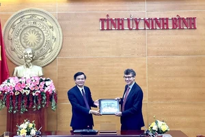 Đồng chí Đoàn Minh Huấn, Ủy viên Trung ương Đảng, Bí thư Tỉnh ủy Ninh Bình tặng quà lưu niệm cho ông Jonathan Baker, Trưởng Văn phòng đại diện của UNESCO tại Việt Nam. (Ảnh: YẾN TRINH)