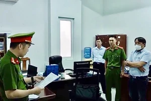 Trần Hữu Dũng (khoanh tay) nghe lệnh bắt bị can từ cơ quan chức năng.