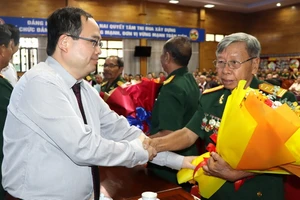 Phó Bí thư Tỉnh ủy, Trưởng Đoàn đại biểu Quốc hội tỉnh Đồng Nai Quản Minh Cường tặng hoa Anh hùng lực lượng vũ trang nhân dân tại buổi họp mặt.