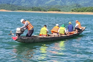 Huyện Quảng Ninh cử các cán bộ phòng, ban chức năng kiểm tra hiện trường hồ Rào Đá và lấy mẫu nước xét nghiệm. (Ảnh: BT)