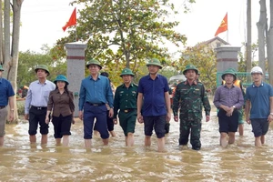 Bí thư Tỉnh ủy Quảng Bình Lê Ngọc Quang (thứ 4 từ phải qua) lội nước lụt đến thăm bà con ở xã Lộc Thủy, huyện Lệ Thủy.