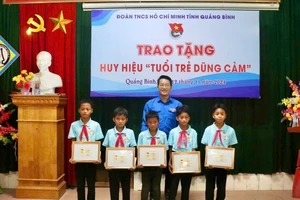 Phó Bí thư Tỉnh Đoàn, Chủ tịch Hội đồng Đội tỉnh Quảng Bình Đinh Trung Hiếu trao tặng Huy hiệu tuổi trẻ dũng cảm cho 5 đội viên.