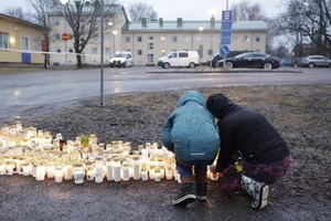 Người dân thắp nến và đặt hoa tưởng niệm nạn nhân trong vụ nổ súng ở trường Viertola, Phần Lan, ngày 2/4/2024. (Ảnh: Reuters) 