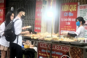 Một quầy bán thức ăn chế biến sẵn trên vỉa hè tại quận Hà Ðông (thành phố Hà Nội).