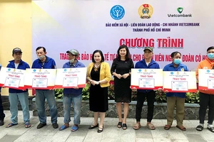 Bà Nguyễn Thị Mỹ Dung, Phó Giám đốc BHXH Thành phố Hồ Chí Minh trao thẻ BHYT tự nguyện cho người có hoàn cảnh khó khăn.