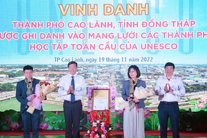 Bà Miki Nozawa, Trưởng Ban Giáo dục Văn phòng UNESCO tại Hà Nội trao chứng nhận cho thành phố Cao Lãnh và nhận biểu trưng, hoa do tỉnh Đồng Tháp trao tặng.