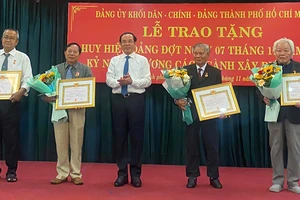 Đồng chí Nguyễn Văn Nên, Ủy viên Bộ Chính trị, Bí thư Thành ủy Thành phố Hồ Chí Minh trao Huy hiệu 55 năm tuổi Đảng và Huy hiệu 50 năm tuổi Đảng cho các đảng viên.