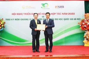 GS, TS Lê Quân (bên phải) trao kỷ niệm chương Vì sự nghiệp phát triển ĐHQGHN cho doanh nhân Đỗ Quang Hiển.