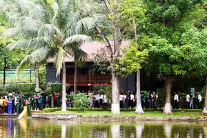 Đông đảo người dân cùng cựu chiến binh tham quan Nhà sàn Bác Hồ trong Khu di tích Chủ tịch Hồ Chí Minh tại Hà Nội. Ảnh: KHIẾU MINH