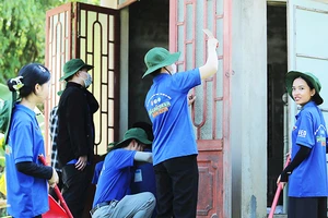 Các tình nguyện viên đang sơn mới nhà cho hộ gia đình chính sách Đỗ Thị Đoan.