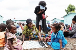 Trẻ em chơi cờ vua trong trại tị nạn. Ảnh: REUTERS