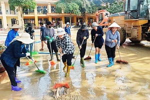 Các cô giáo Trường tiểu học và trung học cơ sở xã Minh Chuẩn, huyện Lục Yên (Yên Bái) tham gia dọn bùn đất sau bão số 3. Ảnh: THANH SƠN