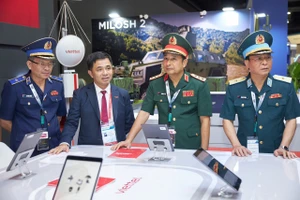 Thượng tướng Phùng Sĩ Tấn cùng các đại biểu tham quan gian trưng bày của Tập đoàn Công nghiệp - Viễn thông Quân đội (Viettel). (Ảnh: MOD)