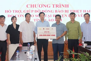 Đại diện Báo Nhân Dân, các nhà tài trợ và lãnh đạo Ủy ban nhân dân huyện Bảo Yên, tỉnh Lào Cai, trao và nhận biểu trưng hỗ trợ nhân dân Làng Nủ, xã Phúc Khánh, huyện Bảo Yên, tỉnh Lào Cai.