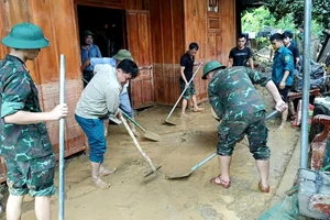 Lực lượng vũ trang và các tổ chức đoàn thể hỗ trợ các gia đình dọn dẹp bùn đất.