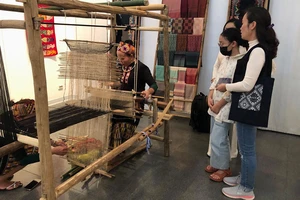 Khách tham quan triển lãm thích thú với phần trình diễn nghề dệt của nghệ nhân dân tộc Thái Thanh.