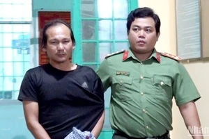 Bắt giữ bị can Nguyễn Hoàng Nam (bên trái) để điều tra.