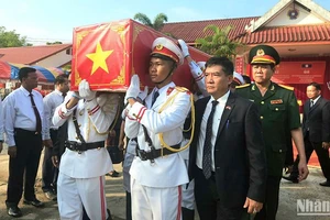 Tiễn đưa 12 bộ hài cốt các liệt sĩ Việt Nam hy sinh tại Lào về nước để an táng. Ảnh: Trịnh Dũng