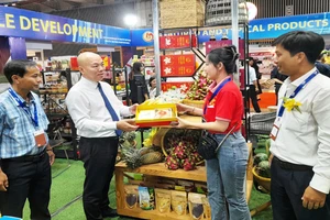 Đại diện Cục Xúc tiến thương mại (Bộ Công thương) tham quan, tìm hiểu các mặt hàng nông sản xuất khẩu của tỉnh Long An tại hội chợ.