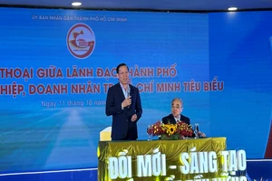 Chủ tịch Ủy ban nhân dân Thành phố Hồ Chí Minh Phan Văn Mãi (người đứng) và Chủ tịch HUBA Nguyễn Ngọc Hòa đối thoại với doanh nghiệp, doanh nhân tại buổi lễ.