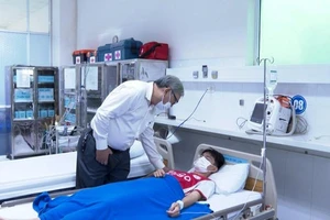 Lãnh đạo nhà trường thăm hỏi các em học sinh đang điều trị tại bệnh viện. (Ảnh: NGỌC HÒA)