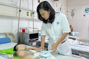 Phó Giáo sư, Tiến sĩ Nguyễn Việt Hoa khám cho bệnh nhi sau phẫu thuật.