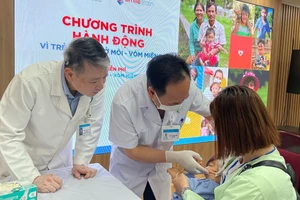 Phó Giáo sư, Tiến sĩ Trần Cao Bính, Giám đốc Bệnh viện, Chủ tịch Hội Răng Hàm Mặt Việt Nam (giữa) thăm khám cho bệnh nhi. 