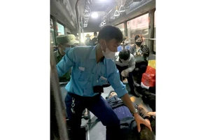 Nhân viên xe buýt đưa người bị thương lên xe để chở đến bệnh viện cấp cứu.