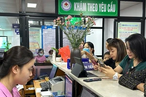 Người bệnh thao tác thanh toán không sử dụng tiền mặt tại Bệnh viện đa khoa Nông nghiệp.