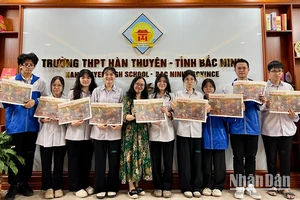 Các học sinh trường THPT Hàn Thuyên (Bắc Ninh) vui thích khi đón nhận ấn phẩm Báo Nhân Dân trao tặng.