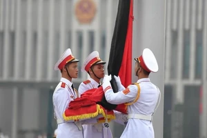 Dải băng tang được buộc vào Quốc kỳ. (Ảnh: TTXVN)