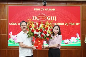 Đồng chí Phó Bí thư Thường trực Tỉnh ủy Đinh Thị Lụa trao quyết định và tặng hoa chúc mừng đồng chí Trần Nguyễn Hiền Anh.