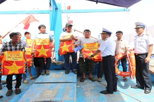 Lãnh đạo Lữ đoàn 955 (Bộ Tư lệnh Vùng 4 Hải quân) tặng cờ Tổ quốc và phao cứu sinh cho bà con ngư dân phường Đông Hải, thành phố Phan Rang-Tháp Chàm, tỉnh Ninh Thuận.
