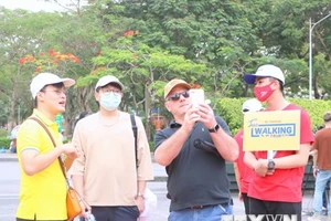 Các vị khách nước ngoài thăm quan khu vực Tượng đài Nữ tướng Lê Chân trong buổi giới thiệu “Hải Phòng-Free Walking tour.” (Ảnh: TTXVN)