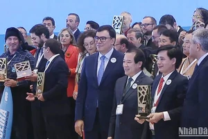 Chủ tịch UBND xã Tân Hóa nhận Giải thưởng “Làng du lịch tốt nhất” của UNWTO với sự chúc mừng của Phó Cục trưởng Hà Văn Siêu và Tổng Thư ký UNWTO Zurab Pololikashvili. (Ảnh chụp từ clip của UNWTO) 
