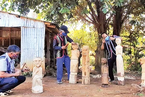 Các nghệ nhân ở xã Ia Ka, huyện Chư Păh (tỉnh Gia Lai) đang sáng tạo, chế tác tượng gỗ.