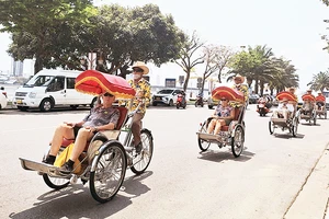 Du khách nước ngoài trải nghiệm tham quan thành phố Đà Nẵng bằng xích-lô.