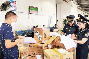 Cán bộ Chi cục Hải quan cửa khẩu sân bay quốc tế Nội Bài (Cục Hải quan thành phố Hà Nội) kiểm tra hàng hóa. (Ảnh HƯƠNG THỦY)