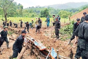 Các chiến sĩ Công an tỉnh Bắc Kạn giúp người dân xã Quang Thuận, huyện Bạch Thông khắc phục hậu quả sạt, lở đất. (Ảnh THÙY DƯƠNG)